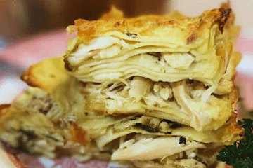 chicken alfredo lasagna on a plate with parsley to the side