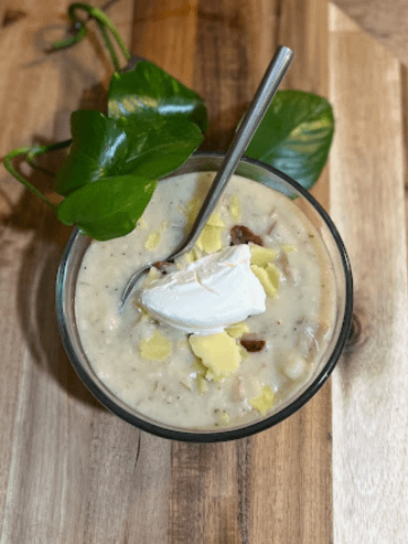 potato soup in a bowl with cheese, bacon, and sour cream